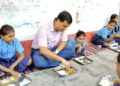 घंटी बजी तो बच्चों के बीच पहुंच गए DM सर… स्कूल में जमीन पर बैठकर खाया मिड-डे मील, फिर खुद धोई थाली